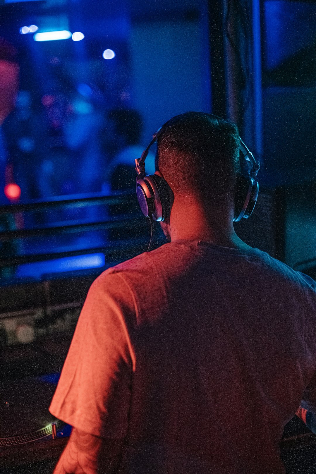 Sound engineer wearing headphones at an audio mixing console